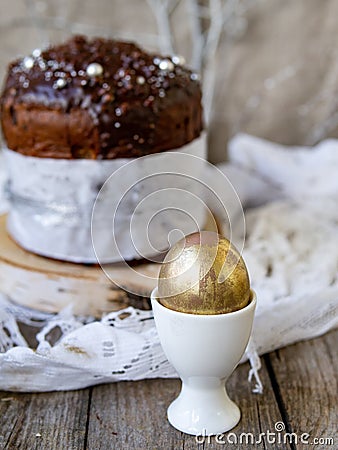 Amazing Chocolate Easter Cake with chocolate drops and dry cherries on an old wooden background with black and golden eggs. Easter Stock Photo