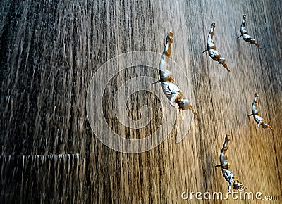 Amazing detail of waterfall in Dubai shopping center. Beautiful perspective of human diver sculptures Editorial Stock Photo