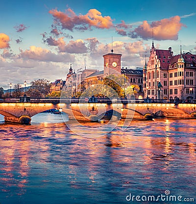 Amazing evening view of Munsterbrucke Bridge and Zurich town hall. Fantastic autumn cityscape of Zurich, Switzerland, Europe. Suns Stock Photo