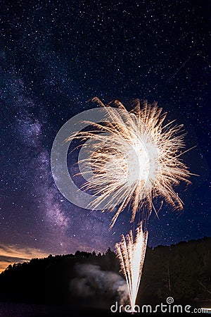 Amazing fireworks display on Lake Joseph, Ontario, with the milky way visible above. Stock Photo