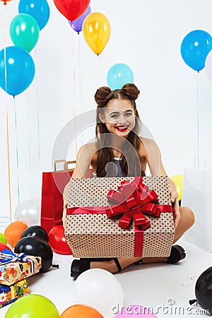 Amazing girl showing present box with red bow, smiling happily Stock Photo