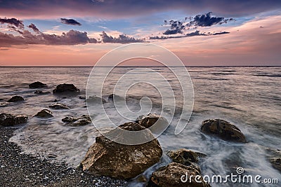 Amazing landscape of sunrise at sea. Colorful morning view of dramatic sky, seascape and rock. Greece. Stock Photo