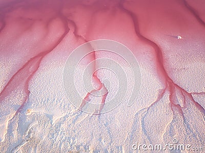 Amazing natural abstract background, bizarre forms of pink water and white salt formations. Aerial view Stock Photo