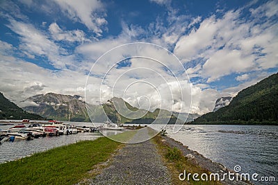 Amazing nature view with pier, fjord and mountain. Pier for boats in front of the view. Scandinavian Mountains, Norway. Artistic Editorial Stock Photo