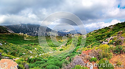 Amazing panorama of rough wild mountains, grass, cloudy blue sky, Lasithi, Crete Stock Photo