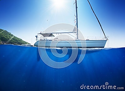 Amazing sunlight seaview to sailboat in tropical sea with deep blue underneath splitted by waterline Stock Photo