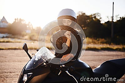 Amazing sunlight. Woman is with motorcycle outdoors Stock Photo