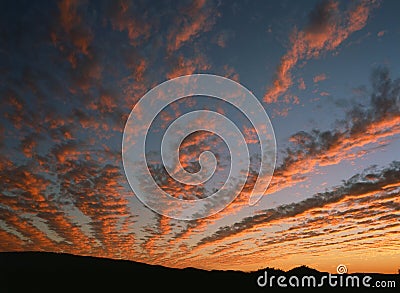 Golden fingers of clouds stretch across the sky Stock Photo