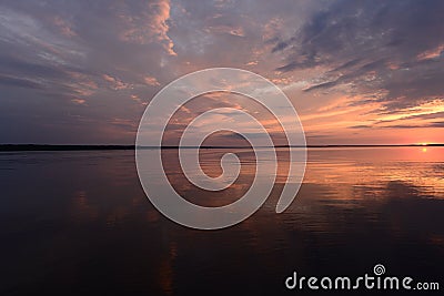 Amazing sunset colors on the lake in the calmness weather in a summer evening Stock Photo