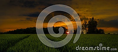 Amazing sunset and sunrise over the windmill and over the grain field Stock Photo