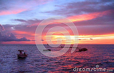 During an amazing sunset, a view from the Nightcliff jetty, Darwin, NT Australia, of two small boats sailing on the sea. Stock Photo
