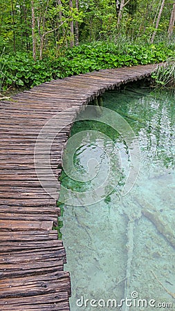 Amazing touristic wooden pathway in the colorful deep forest with clean lakes and spectacular waterfalls, Plitvice National Park, Stock Photo