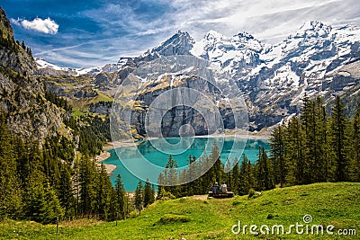 Amazing tourquise Oeschinnensee with waterfalls, wooden chalet and Swiss Alps in Berner Oberland, Switzerland. Stock Photo