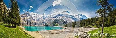 Amazing tourquise Oeschinnensee with waterfalls, wooden chalet and Swiss Alps, Berner Oberland, Switzerland Stock Photo