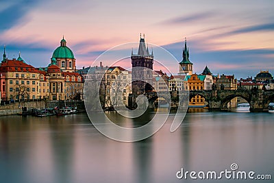Amazing towers of Charles bridge with reflection at Vltava river during cloudy sunset, Prague, Czech republic Stock Photo