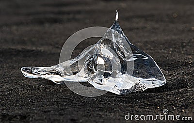 Amazing transparent blue iceberg pieces on Diamond beach with black sand near Jokulsarlon lagoon, Iceland. Ice calving. Black and Stock Photo