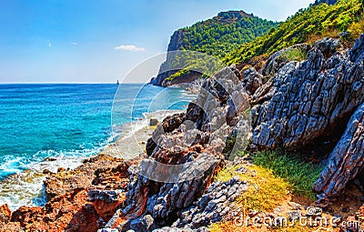 Amazing view on rocky tropical beach on sunny summer day in Turkey. Turkish seascape with mountains and rocks on coastline Stock Photo