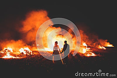 Amazing wedding couple near the fire at night Stock Photo