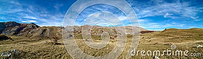 Amazing wide horizontal panorama of mountain range landscape during beautiful blue sky day in the autumn as panoramic view of Stock Photo