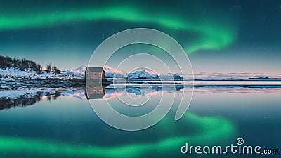 Amazing winter night landscape with northern lights or aurora borealis over the mountains, lonely rorbu, starry sky and reflection Stock Photo