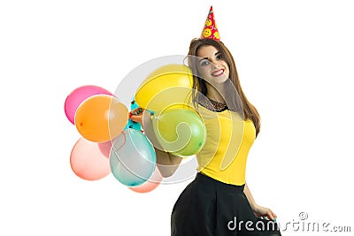 Amazing young girl in a bright dress smiles and holds in her hand a lot of hot air balloon Stock Photo