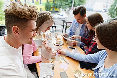 Attractive young friends relaxing at the cafe on a blurred background. Communication concept. Stock Photo