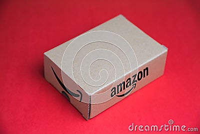 Amazon logotype on cardboard box , on a red background Editorial Stock Photo