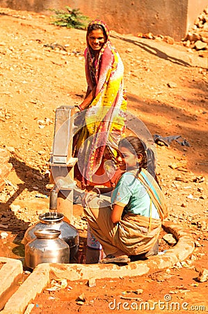 Ambaji: Two young indian women filling their water-bowls Editorial Stock Photo