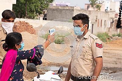 Ambala City, Haryana/India -04/30/2020 Health workers checking body temperature of police during Routine Checkup to avoid covid i Editorial Stock Photo