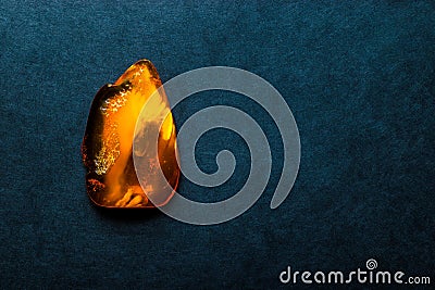 Amber Stone on Dark Blue Background Surface With Free Space Stock Photo