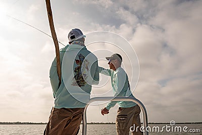 A fishing guide instructs a fly fisherman on bonefishing technique in Belize, Central America Editorial Stock Photo
