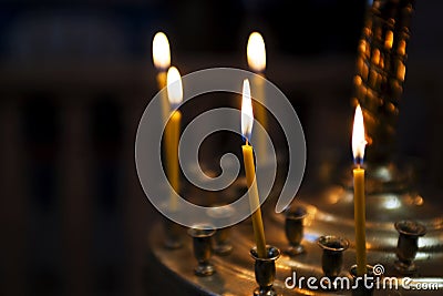 Ambiance of church, light of candles. Candles in a church. Light of candles in the church on the dark background Stock Photo