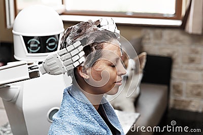 Ambient assisted living household robot is washing the hair of an adult woman Stock Photo