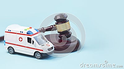 Ambulance car and brown gavel stethoscope and on a blue background. symbol photo for bungling and medical error Stock Photo