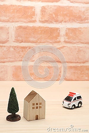 Ambulance and house in front of brick wall. Stock Photo