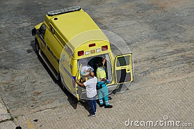 Ambulance personnel and cruise ship crew on a dock in Aruba taking a passenger off the ship Editorial Stock Photo