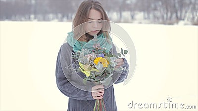 Ame com uma menina em uma camiseta cinzenta com um ramalhete das flores em um lago congelado filme Ame com uma menina em uma camiseta cinzenta com um ramalhete das flores em um lago congelado filme