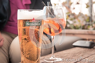 Heineken, Toast, Cold beer on the table, white wine, people drink together in the summer Editorial Stock Photo