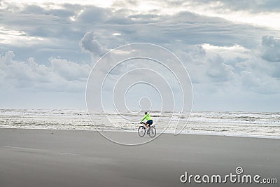 Young woman cycles on the beach during the sunset Editorial Stock Photo