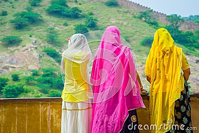 Amer, India - September 19, 2017: Unidentified women posing in a stoned wall, wearing a yellow and pink clothes, and Editorial Stock Photo