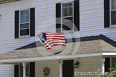 American Colonial Flag Hanging In Front Of Home Stock Photo