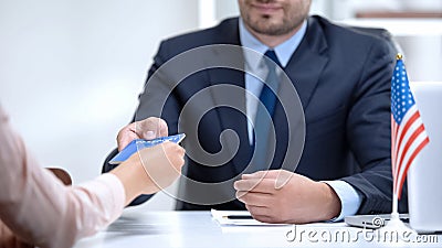 American consular officer giving passport to female immigrant, refugee visa Stock Photo