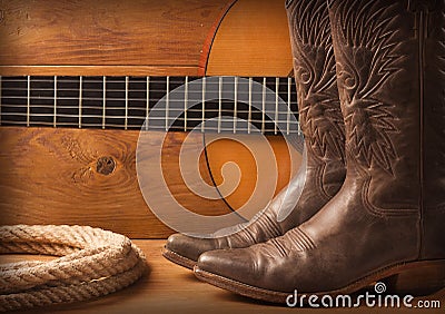American Country music with guitar and cowboy shoes on wood text Stock Photo