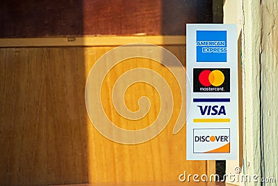 American Express, MasterCard, VISA, Discover payment options advertised on a restaurant door Editorial Stock Photo