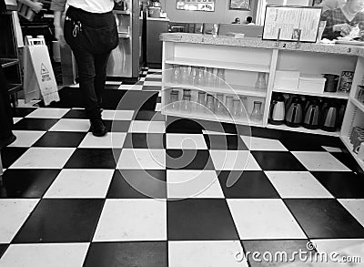 American Fifties Diner - Waitress Walking on Black and White Checkerboard Floor Editorial Stock Photo