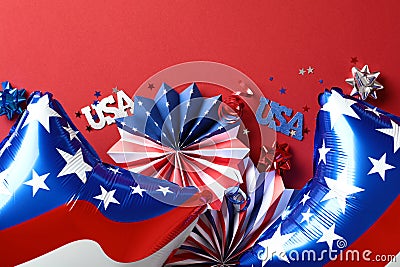 American flag balloons, paper fans, decorations on red background. Stock Photo