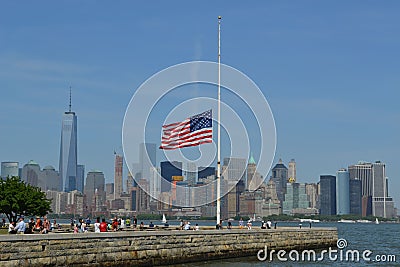 the american flag flies at half mast overlooking a city skyline Editorial Stock Photo