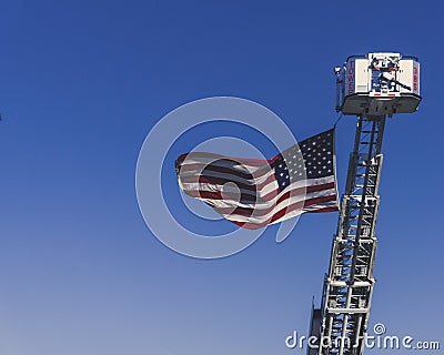 An American Flag is Hoisted Up by a Fire Truck in Remembrance on September 11th, 2018 Stock Photo