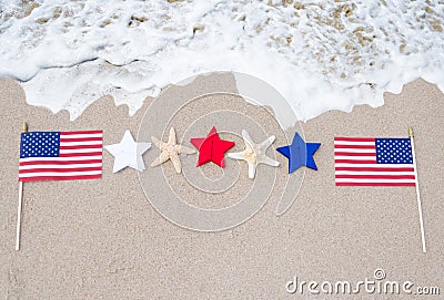 American flags with starfishes on the sandy beach Stock Photo