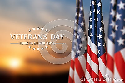 American flags with Text Veterans Day Honoring All Who Served on sunset background. Stock Photo